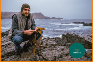 7 Fathoms Co-founder Terrence Howell in Grates Cove with seaweed